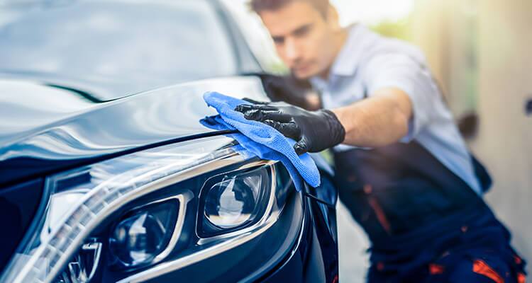 A person cleaning their vehicle while spring cleaning their garage