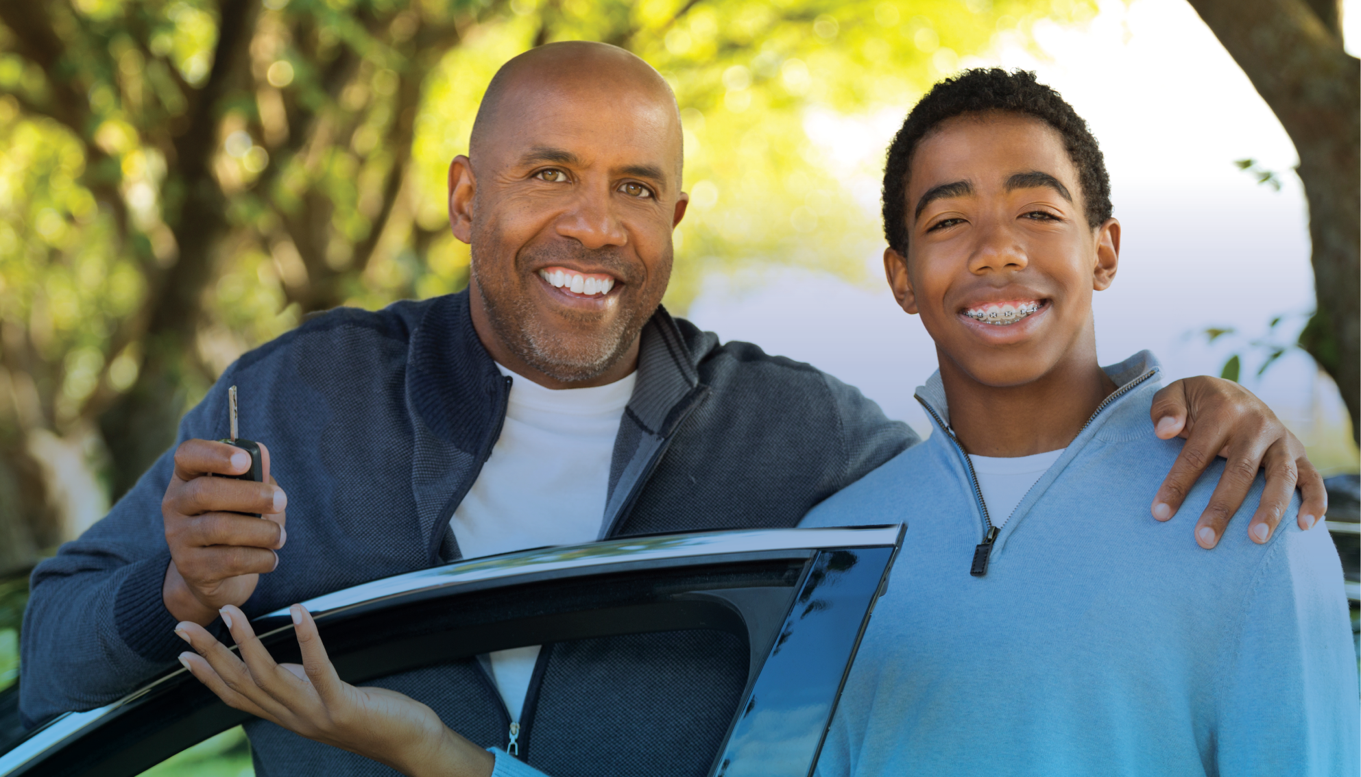 Dad handing over car keys to his son for safe teen driving